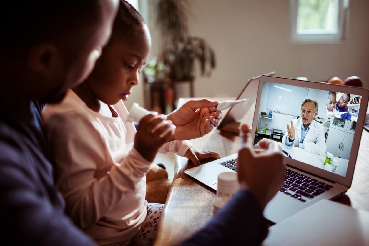 A family using telemedicine to have a virtual check-up through their computer with a physician.