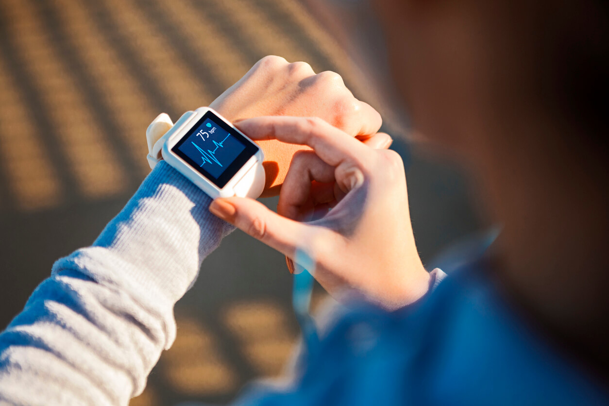 A woman checking her heartbeat on an internet-enabled smartwatch.