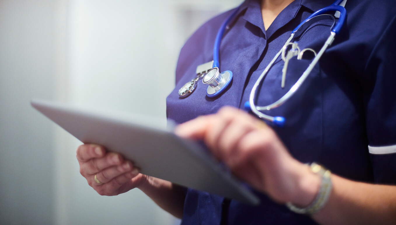 A healthcare provider using an internet-enabled device to look up information on a patient.